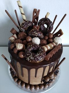 there is a chocolate cake decorated with candies and donuts