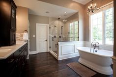 a large bathroom with a tub, sink and shower