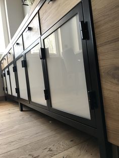 a large cabinet with glass doors on the front and sides in a room that has wooden floors