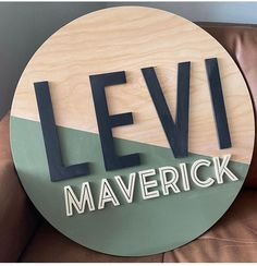 a wooden sign that says levi maverick on the side of a brown couch