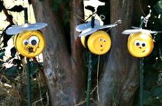 three yellow smiley faces are attached to the poles in front of some trees with eyes on them