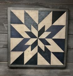 a black and white quilt hanging on a wooden wall