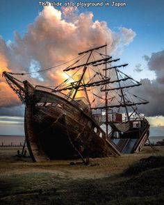 an old ship sitting on top of a dry grass field