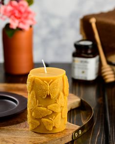 a yellow candle sitting on top of a wooden tray