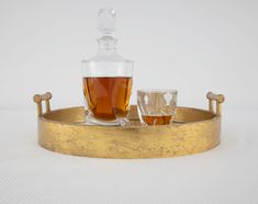 two glasses and a decanter sitting on a tray