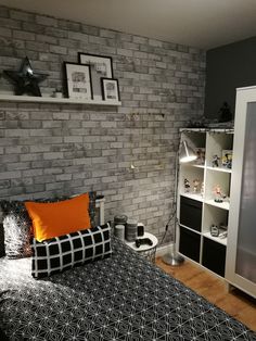 a bed room with a neatly made bed and a book shelf on the wall next to it