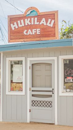 the front of a restaurant with signage on it's roof and doors open to let people know where they are going