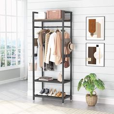 an open closet with clothes and shoes hanging on the wall next to a potted plant