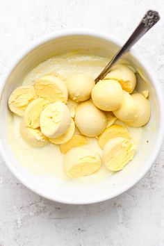 a bowl filled with ice cream and peeled bananas