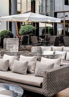 an outdoor seating area with chairs and umbrellas