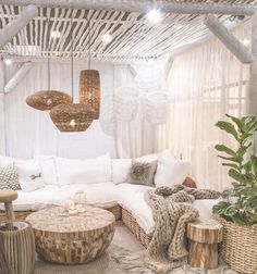 a living room filled with lots of white furniture and decor on top of wooden tables