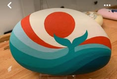 a painted rock sitting on top of a wooden table