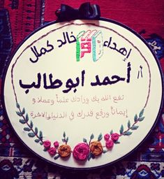 the sign is decorated with colorful flowers and arabic writing on it's side, along with a black bow