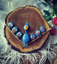 three blue birds sitting on top of a piece of wood