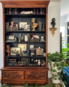 an old bookcase with many books and pictures on the top shelf in a living room