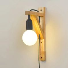 a light that is on the wall next to a wooden frame with a lamp in it