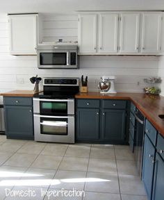 a kitchen with blue cabinets and stainless steel appliances