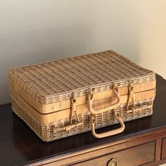 a wicker box sitting on top of a wooden table next to a drawer with drawers