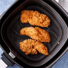 three pieces of fried chicken cooking in an air fryer