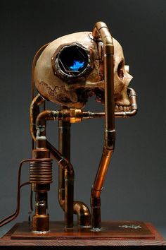 a sculpture of a human skull with an eyeball in it's head and pipes coming out of its mouth