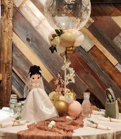 a table topped with a bride and groom figurine next to a balloon filled with flowers