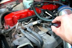 a man working on an engine in his car