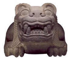 an animal statue with its mouth open and eyes wide open, sitting in front of a white background