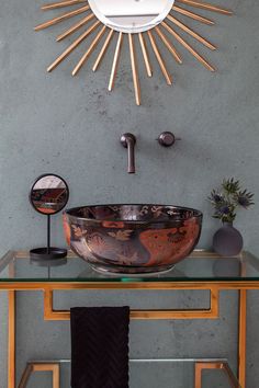 a bathroom sink sitting under a sunburst above a mirror