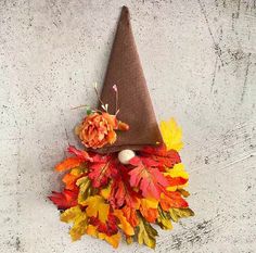 a brown hat with leaves and flowers on the top is sitting on a concrete surface