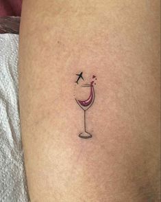 a woman's thigh with a small tattoo of a wine glass on the side