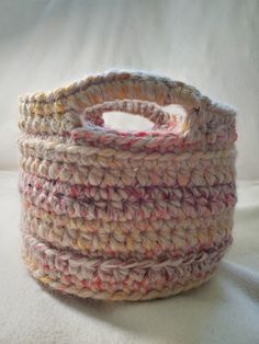 a crocheted basket sitting on top of a white surface