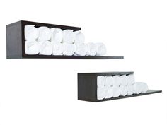 two black shelves with white towels on them