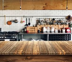 a wooden table sitting in front of a stove top oven next to a counter with pots and pans on it