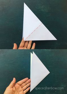 someone is making an origami triangle out of paper and then fold it in half