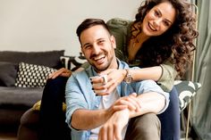 a man sitting on the back of a woman who is holding a remote control in her hand