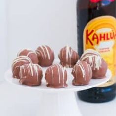 chocolate truffles on a white plate next to a bottle of kahlua