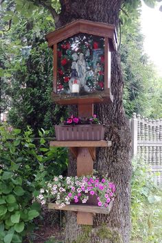 a bird house with flowers in the tree