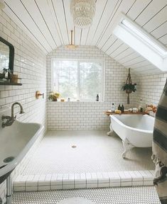 a white bath tub sitting under a window next to a sink