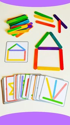 some colored pencils are next to different shapes and sizes of cards on a white surface