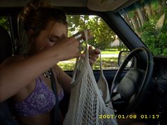 a woman in a car holding two bags