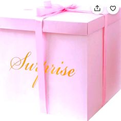 a pink gift box with the word surprise written on it and a bow tied around the top