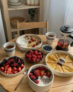 a table topped with bowls of fruit and desserts