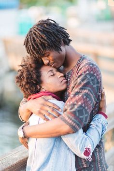 two people embracing each other on a bridge