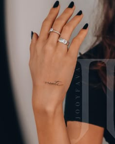 a woman's hand with a small tattoo on her left wrist and the word love written in cursive writing