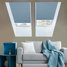 two skylights are above a couch in a living room with blue and white decor