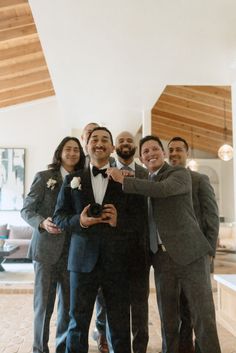 a group of men standing next to each other in front of a living room ceiling