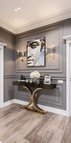 an elegant dining room with gray walls and wood flooring, framed artwork on the wall