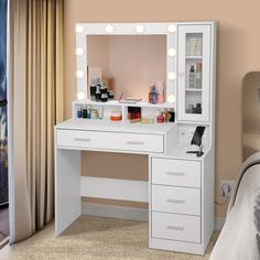 a white vanity with lights on it and a bed in front of the window behind it