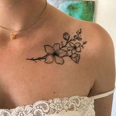 a woman with a tattoo on her shoulder and flowers in the middle of her chest