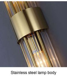 two brass colored tubes are attached to the wall with clear glass strips on each end